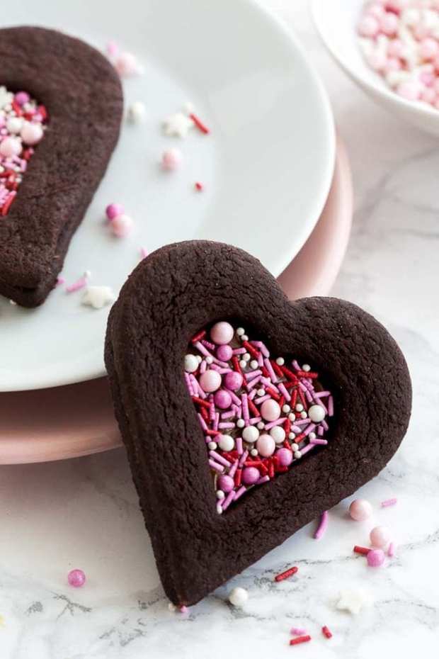 These soft Chocolate Sugar Cookies are perfect for Valentine’s Day! Filled with Nutella and decorated with sprinkles, these easy heart-shaped chocolate sandwich cookies have a tender center, crisp edges, and make a great edible Valentine’s gift. Kids and adults alike will love these cute homemade treats!