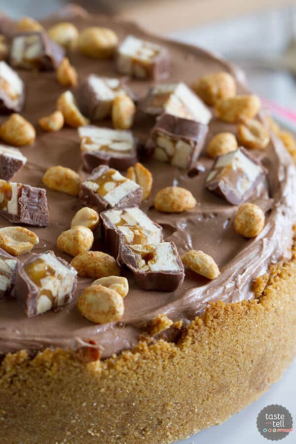 This Snickers Cheesecake has a graham cracker crust, chunks of Snickers candy bars, a creamy cheesecake layer, then a smooth, chocolate cream cheese frosting.