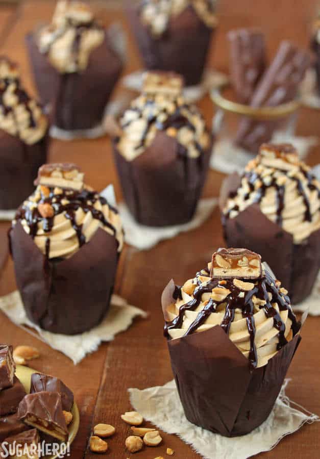 In these Snickers Cupcakes, plain chocolate cupcakes are transformed into decadent, candy-bar inspired creations, featuring a peanut caramel filling, fluffy peanut butter frosting, and LOTS of chocolate and candy bars.