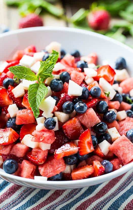 A patriotic Red, White, and Blue Fruit Salad tossed with a minty dressing is perfect for a 4th of July BBQ or any summer picnic.