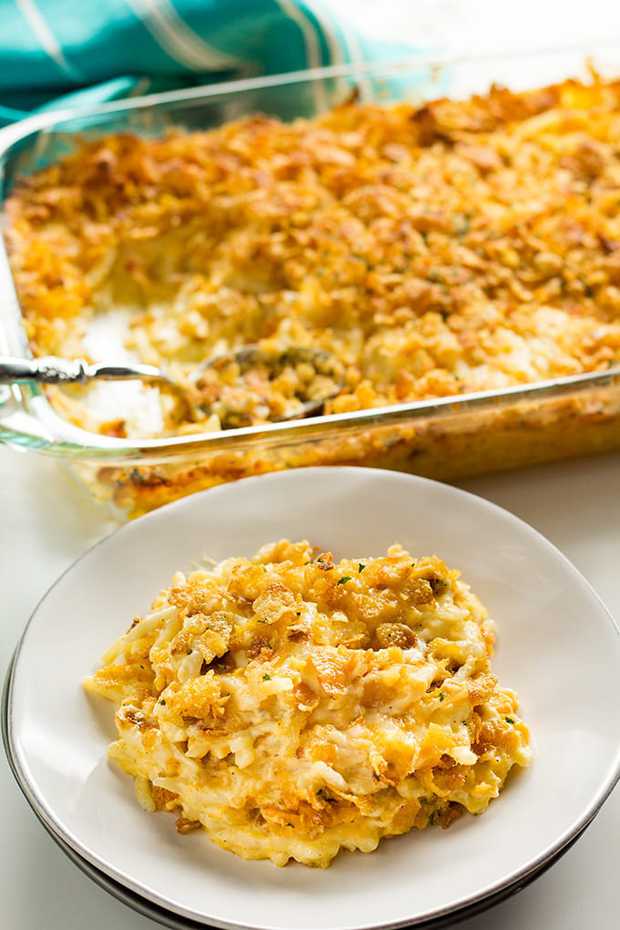 Cheesy Hashbrown Casserole is a classic holiday and potluck side that is cheesy, creamy, and easy to make!  This casserole is filled with cheese, sour cream, hash brown potatoes and a tasty cornflake topping!