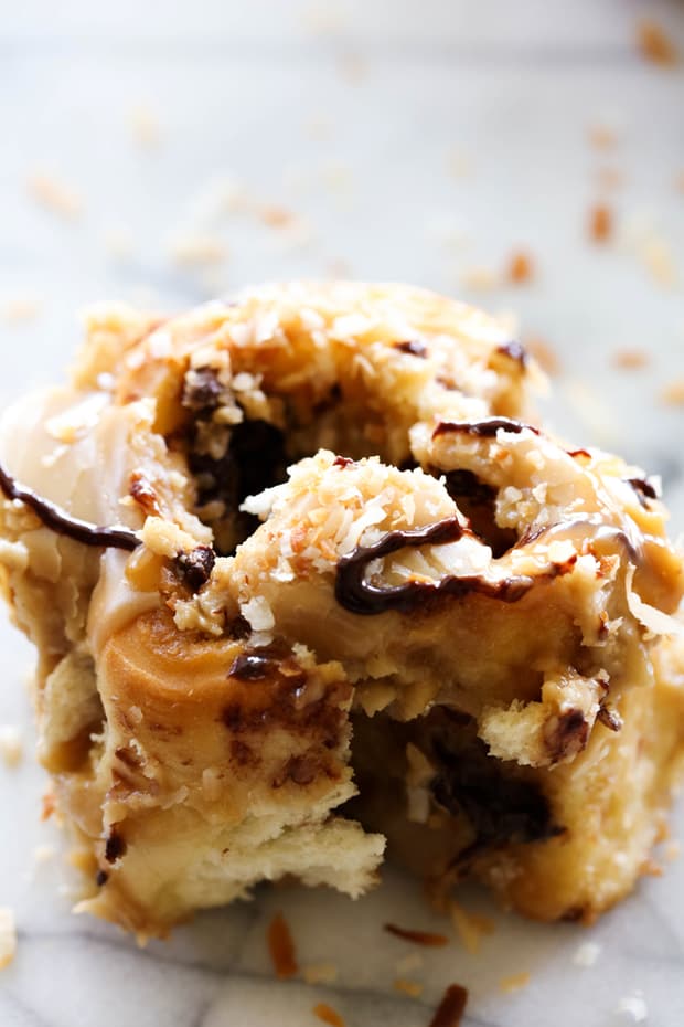 These Samoa Sweet Rolls are made with a super simple cake-mix dough and have a delicious brown sugar toasted coconut filling and mini chocolate chips. They are topped with THE BEST caramel frosting, garnished with toasted coconut and drizzled with caramel and chocolate. They are unbelievably good