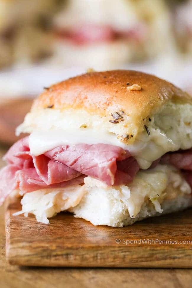 Reuben Sandwich Sliders make the perfect party food or easy weeknight dinner!  Dinner rolls are loaded up with all of your favorite Reuben sandwich fillings, topped with a seasoned buttery topping and baked until warm and melted.  This is going to be your go-to party dish!