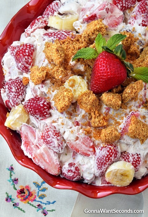 Strawberry Cheesecake Salad-this super delicious salad is absolutely loaded with strawberries tossed in a thick, rich and creamy cheesecake mixture ,then topped off with a yummy graham cracker crust crumble!