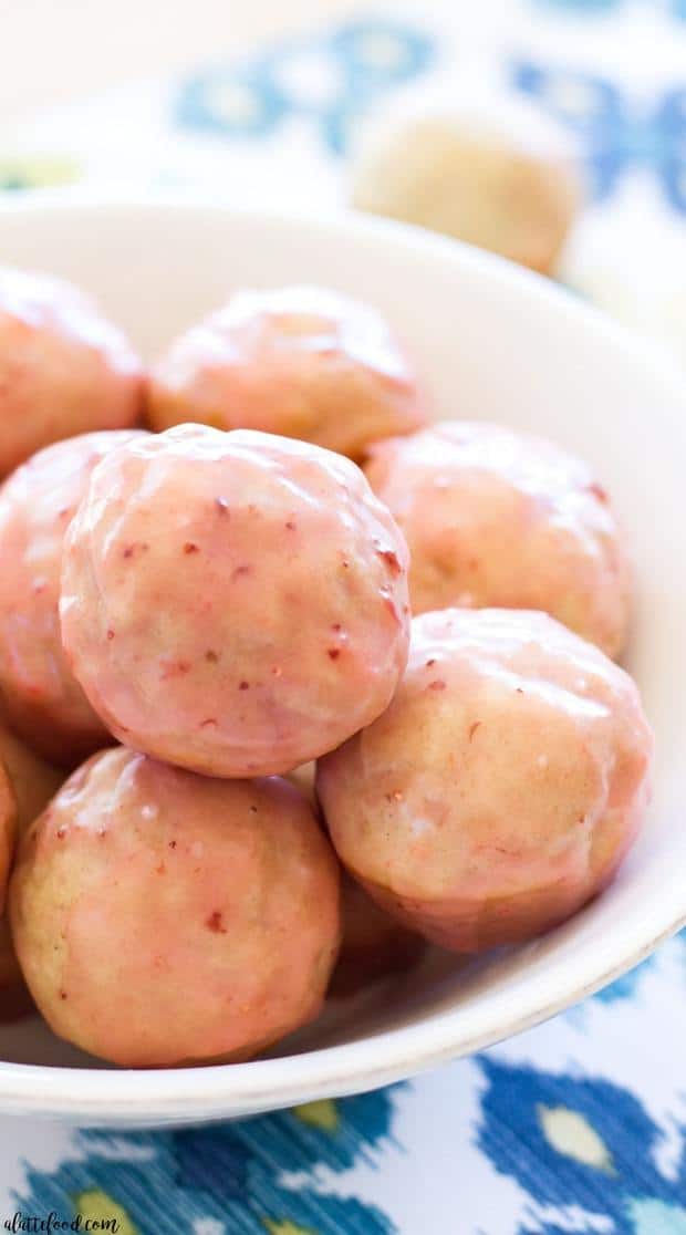 These easy homemade donut holes are baked not fried! They are dunked in a homemade strawberry glaze, making this donut hole recipe the perfect spring dessert or brunch!