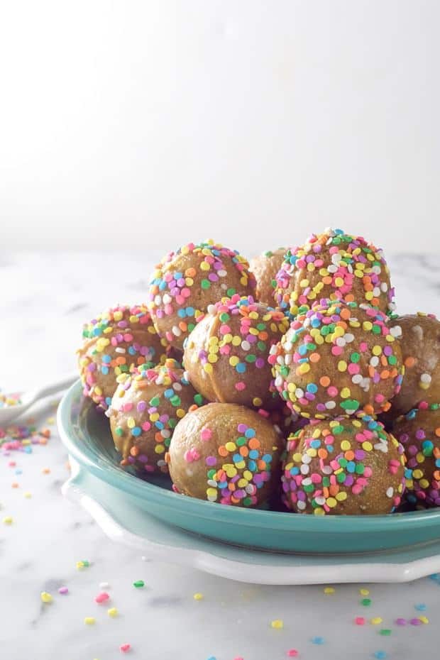 An easy, one bowl birthday cake in the form of donuts! Baked Vanilla Funfetti Donut Holes bake quickly and filled with sprinkles!
