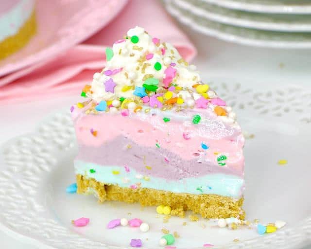 This creamy, dreamy, luscious, no-bake pie is what unicorn dreams are made of. The easy, 4-ingredient fruity pastel filling is studded with confetti sprinkles, layered on top of a graham cracker crust and frozen into a layered ice cream dessert. All topped off with a whimsical unicorn and more sprinkles!
