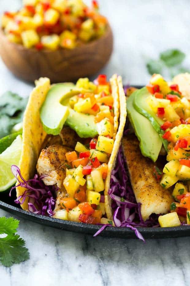 This recipe for Tilapia Fish Tacos is seasoned fish layered with cabbage, avocado and a tropical salsa, all tucked inside warm corn tortillas. It's a meal that's fast, fresh, healthy and ready in 20 Minutes!