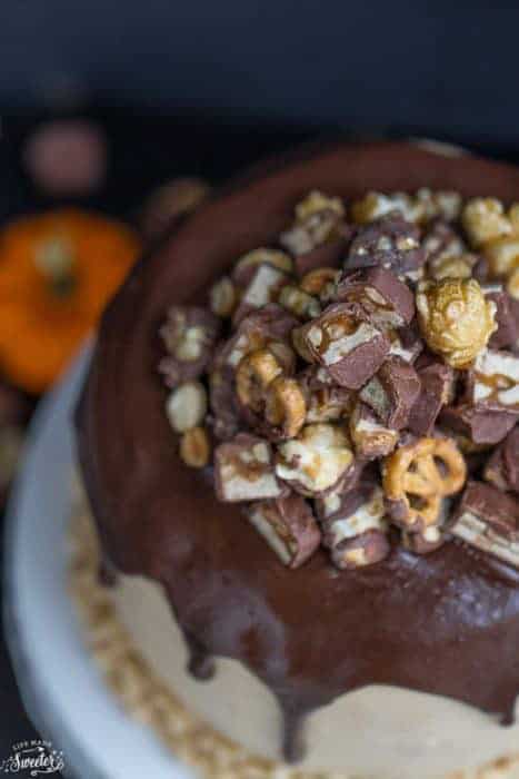 Pumpkin Snickers Layer Cake with Salted Caramel Frosting makes the perfect celebration cake. Best of all, it’s full of three layers of pumpkin cake with Snickers, salted caramel frosting topped with chocolate ganache, Snickers and caramel popcorn.