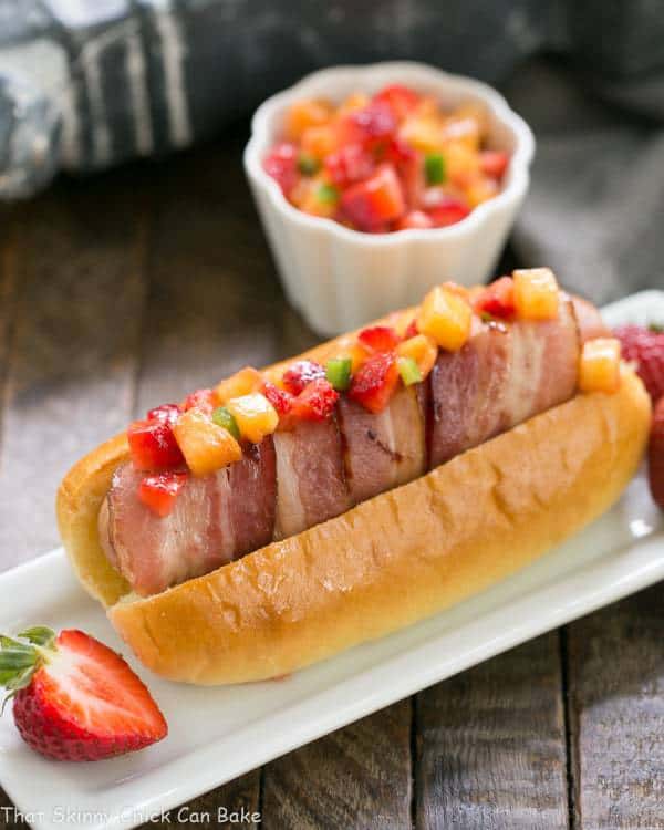One hot dog a year is the max for this skinny chick.  But after making these sumptuous Bacon Wrapped Hot Dogs topped with fruit salsa, my tune has changed!