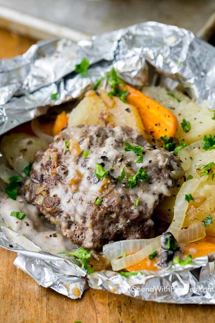  Hobo Dinner Foil Packets are so simple to make and everyone raves about them! Comforting veggies including potatoes, carrots and onions are topped with a seasoned hamburger patty and grilled or baked to tender perfection.