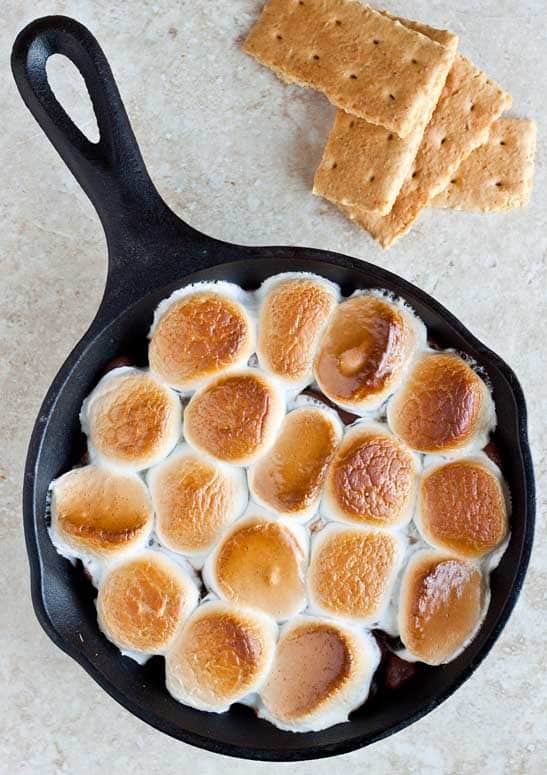 Indoor s’mores, baked s’mores dip made in a cast iron skillet. Scoop up with graham crackers and devour!