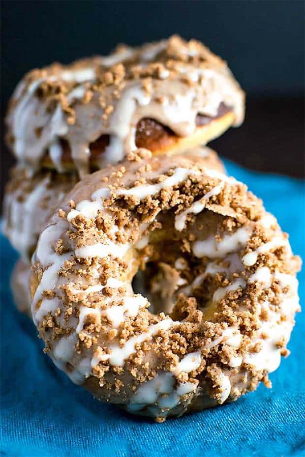 Cinnamon Bun Style Baked Donuts covered in cinnamon glaze, cinnamon crumbles, and vanilla frosting. Get the best of both sweet breakfasts in one!