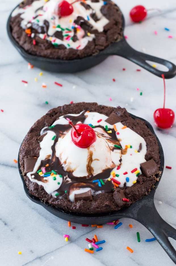 Skillet Brownie Sundaes!  These mini skillets are filled with warm fudgy brownies loaded with chunks of chocolate and topped with ice cream, chocolate syrup, sprinkles and of course the cherry on top!  Perfect small batch dessert for two!