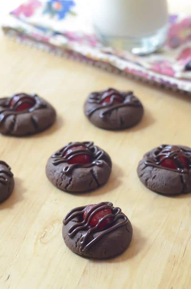 If you are a fan of chocolate and cherries (and who isn’t?) you’ve got to try these Chocolate Covered Cherry Cookies. Fudgy, brownie-like cookies with a sweet cherry peeking through a drizzle of cherry infused chocolate frosting.