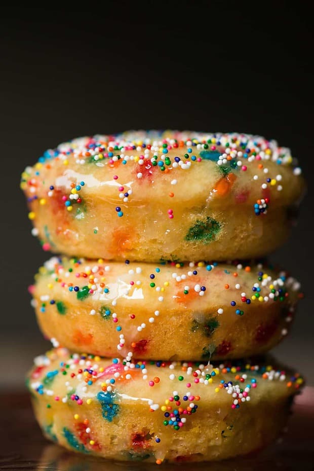 These Birthday cake Baked Donuts will put a smile on anyone’s face! Light and fluffy buttermilk donuts are filled with sprinkles. The baked donuts are then dipped in a warm glaze and topped with more sprinkles! Make them for breakfast or dessert!
