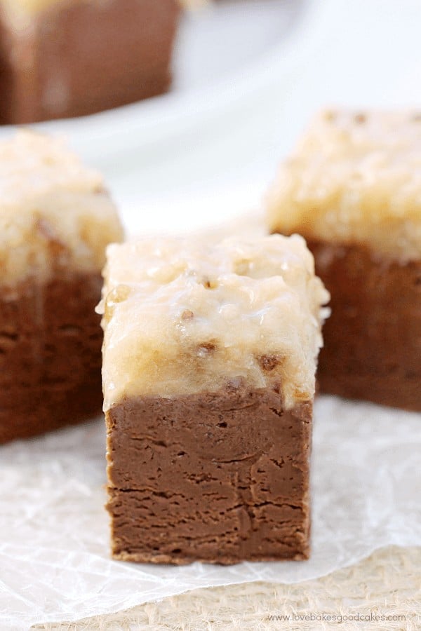 This German Chocolate Fudge will be the talk of the holidays! Thick chocolate fudge topped with a gooey coconut pecan icing!