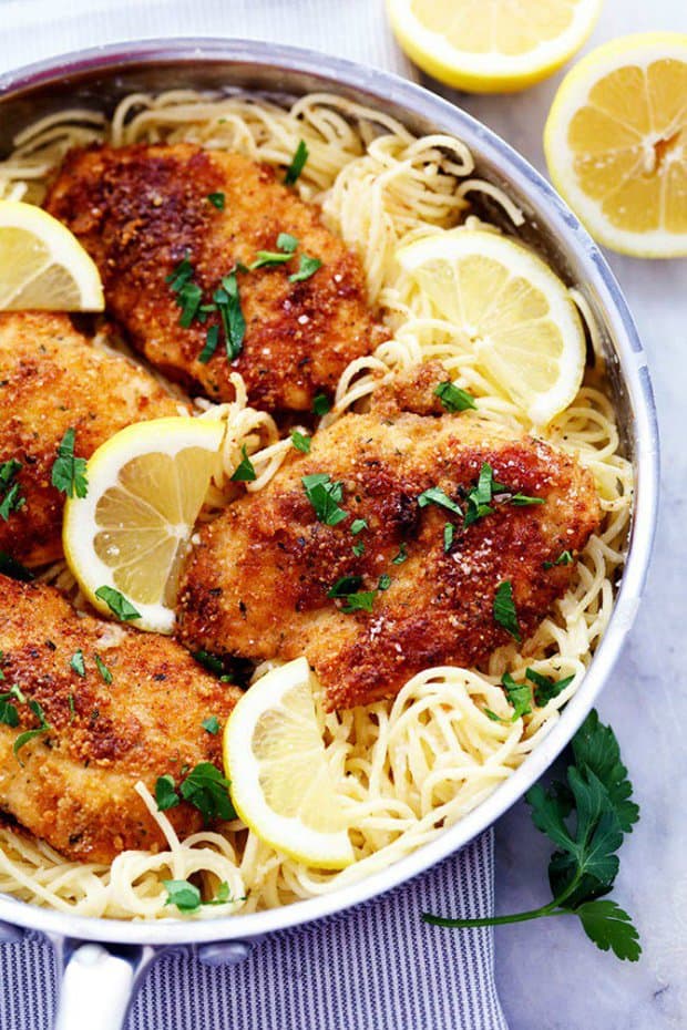 Crispy, tender and juicy parmesan crusted chicken over the most incredible creamy lemon garlic pasta! This is a must make meal!