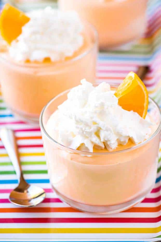 A quick eggless orange mousse recipe that's served up parfait style and garnished with whipped cream and orange slices. Plus, this is an orange mousse recipe without gelatin, making it a fool-proof treat for any orange creamsicle fan!