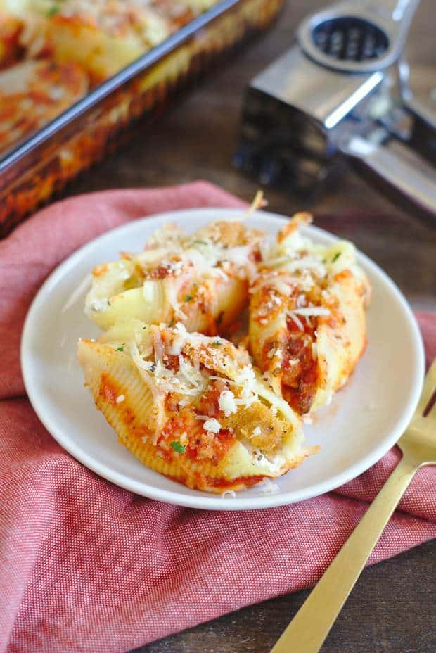 Chicken Parmesan Stuffed Shells – Delicious stuffed shell pasta filled with cheese and crispy chicken, topped with marinara sauce and more cheese! Chicken parmesan stuffed shells are an easy and delicious weeknight meal that is sure to be a new family favorite!