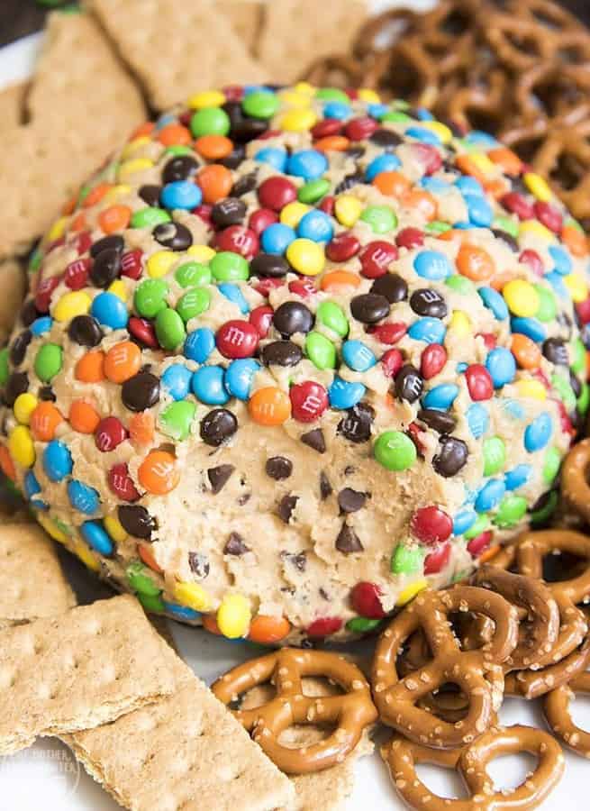  Monster Cookie Dough Dip Cheeseball is a delicious peanut butter dessert dip that tastes like monster peanut butter cookies and peanut butter cookie dough. Its perfect served with pretzels, graham crackers, and other cookies!