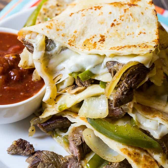 Philly Cheese Steak Quesadillas are filled with melted provolone cheese, tender crisp onions and peppers, fresh mushrooms, and seared steak slices. If you love a Philly Cheese Steak sandwich, you will love these quesadillas. They are perfect for game day!