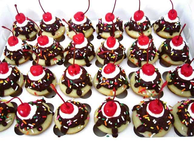 Fluffy vanilla cupcakes topped with chocolate frosting, a fudge drizzle, sweet swirls of vanilla buttercream, sprinkles and a cherry on top!