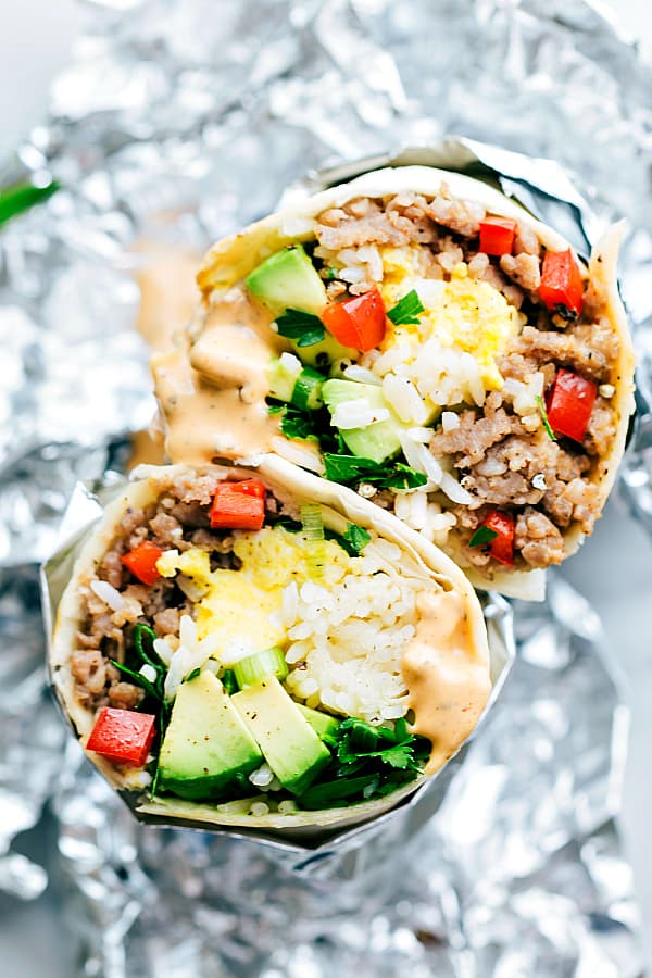 Breakfast Sausage Avocado Burritos are loaded with sausage, eggs, tomato, and rice and drizzled in a sriracha mayo dressing.  These will become a new favorite breakfast that will blow your tastebuds away!