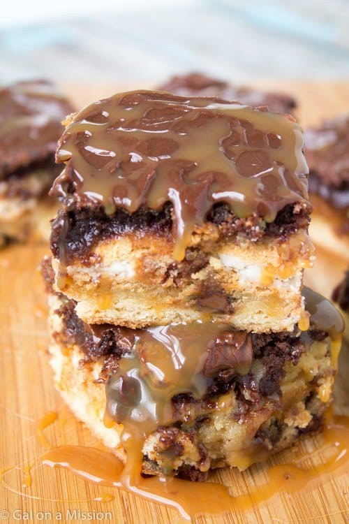 A sinful five-layer brownie bar recipe: chocolate chip cookie dough, golden Oreos, fudgy brownies, chocolate ganache, and caramel sauce drizzled on top.