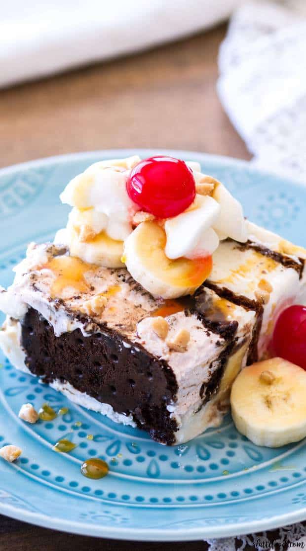 This Banana Split Ice Cream Sandwich Cake is a fun twist on the classic banana split dessert. Ice Cream Sandwiches, bananas, caramel sauce, hot fudge, whipped cream, and cherries make up this super pretty ice cream dessert! This easy no bake ice cream sundae dessert is the perfect way to cool off during the summer!