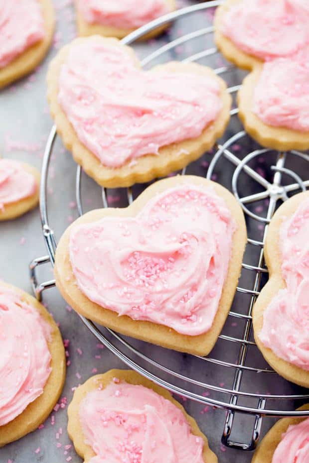 Cut out homemade Sugar Cookies that have a crisp edge and the softest center!  Topped with my favorite cream cheese frosting and sprinkles this is a tried and true family sugar cookie recipe!  You will agree that they are the BEST