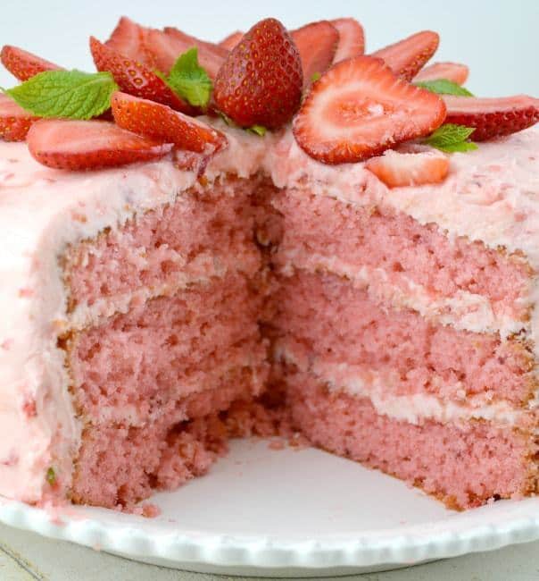 Our Easy Strawberry Triple Decker Cake Recipe is an absolute showstopper. Loaded with Fresh Strawberries, this Homemade Southern Delight is guarentted to be a hit! Super Moist, Rich and Really Sweet, all topped with Strawberry Buttercream Frosting!!