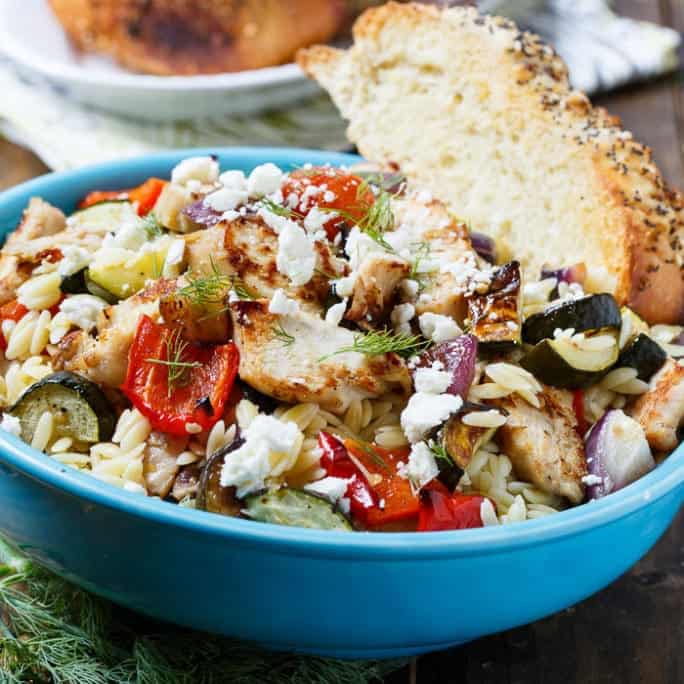  Orzo Pasta Salad with Grilled Chicken and Roasted Vegetables is a one bowl meal that’s full of flavor.  It’s loaded with zucchini, red onion, red bell pepper, and cherry tomatoes, plus a little crumbled feta cheese and fresh dill. Everyone in my family loves pasta salad so much that I often transform it from a side dish into a main dish by adding a protein.
