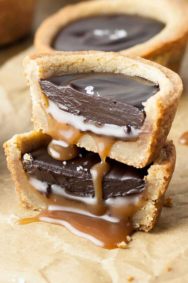 Chewy Caramel Cookie Cups loaded with gooey caramel and topped with a silky dark chocolate ganache.