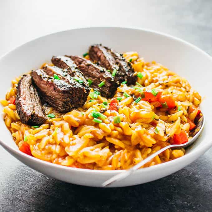 Enjoy marinated skirt steak served over a bed of creamy tomato orzo pasta simmered with Italian spices.
