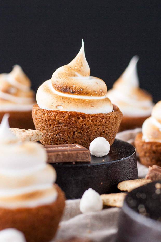 No campfire needed for this S'mores Cookie Cups! Graham cracker cookie cups filled with a hershey's milk chocolate ganache, topped with toasted homemade marshmallow fluff.