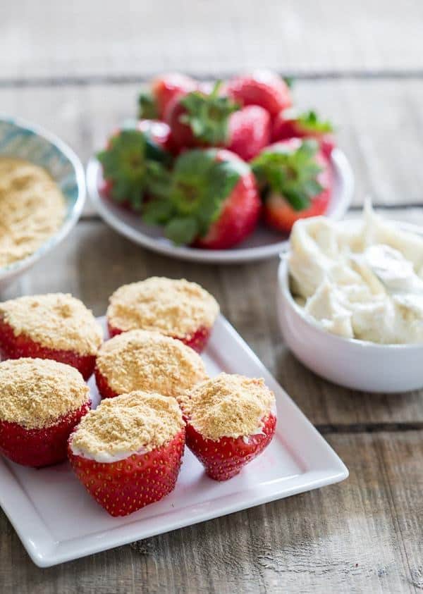 These cheesecake stuffed strawberries are packed full of creamy cheesecake and topped with a dusting of graham cracker crumbs. A perfect 2 bite dessert!