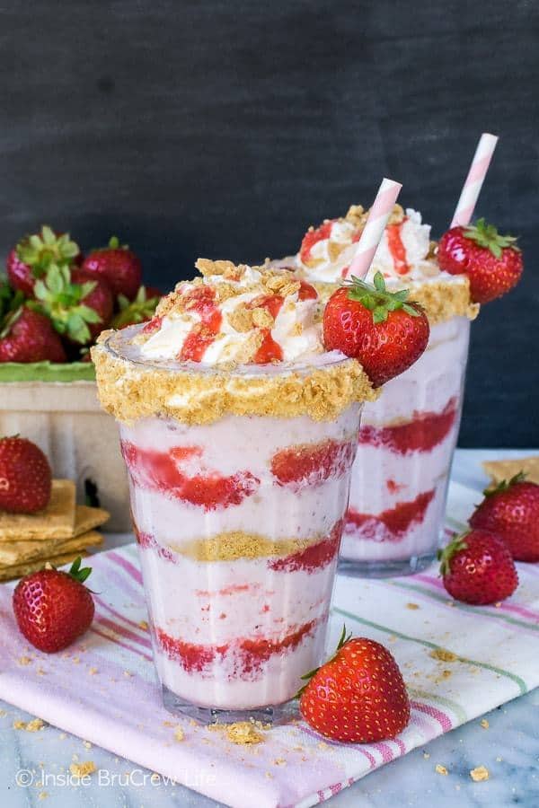 Swirls of strawberries and graham cracker crumbs give these Strawberry Cheesecake Milkshakes a fun flair. These frozen drinks are a great way to cool off on a hot day.