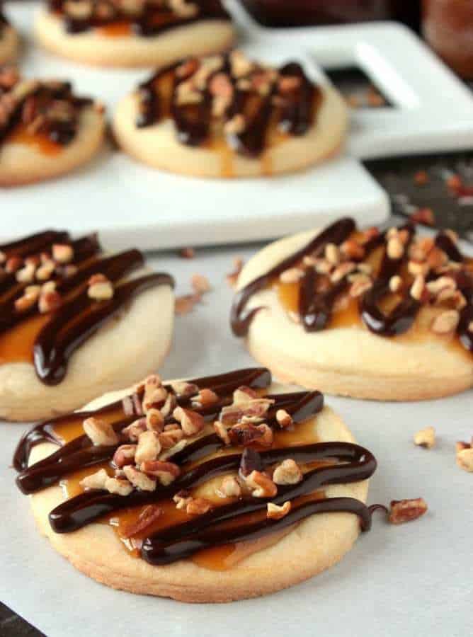 Turtle Shortbread Cookies are homemade shortbread cookies have a caramel sauce center, they’re drizzled with homemade chocolate sauce and topped with chopped pecans!