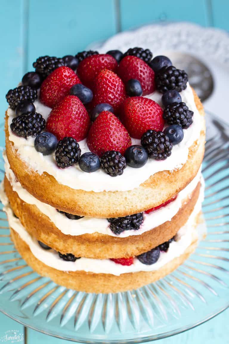 Easy Berries and Cream Sponge Cake makes the perfect celebratory dessert for summer.  Best of all, it’s easy to customize with your favorite berries. Made with layers of vanilla sponge cake, stabilized whipped cream, and fresh ripe strawberries, blueberries and blackberries.