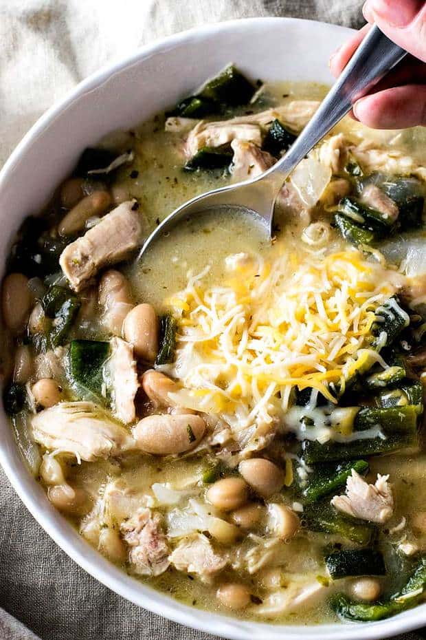 A chicken chili recipe made with whole chicken, homemade chicken broth, tender poblano chilis, and flavorful cannellini beans for an new dinner favorite!