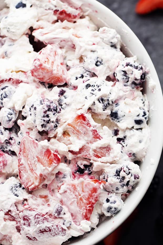Very Berry Cheesecake Salad includes fresh berries combined with a creamy cheesecake fluff.  This is so amazing and will be the hit of any gathering!