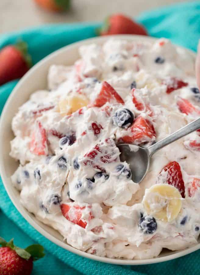 Cool and creamy no bake cheesecake filling is folded into a mixed berry fruit salad. The red white and blue colors make it perfect for any summer potluck!