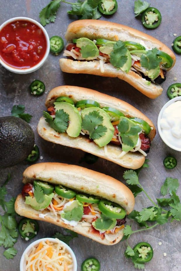  These hot dogs are grilled to perfection, then topped with jalapeno peppers, salsa, cheese, sour cream and avocados.