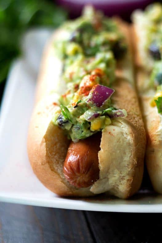 It’s a mashup of America’s favorite barbecue food with America’s favorite Mexican appetizer. Barbecue season is in full swing and I’m always up for Mexican food. So, let’s add some major pizzazz to your next barbecue with these zesty southwestern-inspired dogs!