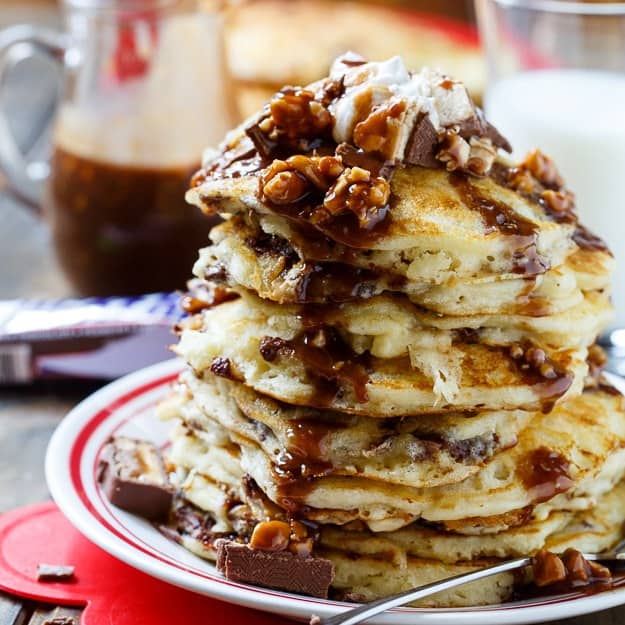 Snickers Pancakes with Snickers Syrup make a truly special breakfast. Chopped candy bars are added to the batter and melted to make a syrup