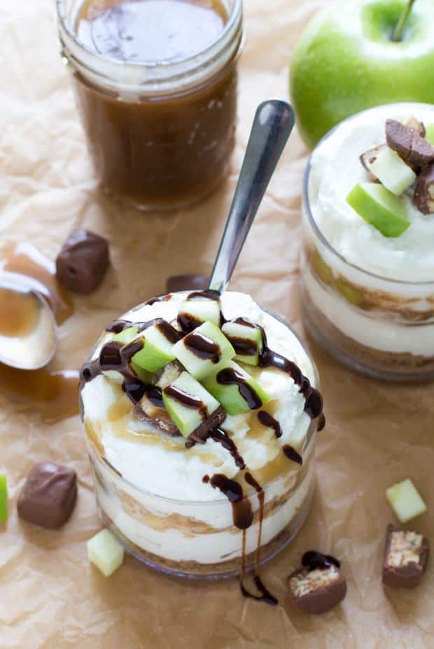 Individual Snickers Apple Cheesecake made with caramel sauce, cheesecake filling, apples and snickers bites. The perfect dessert for Fall!