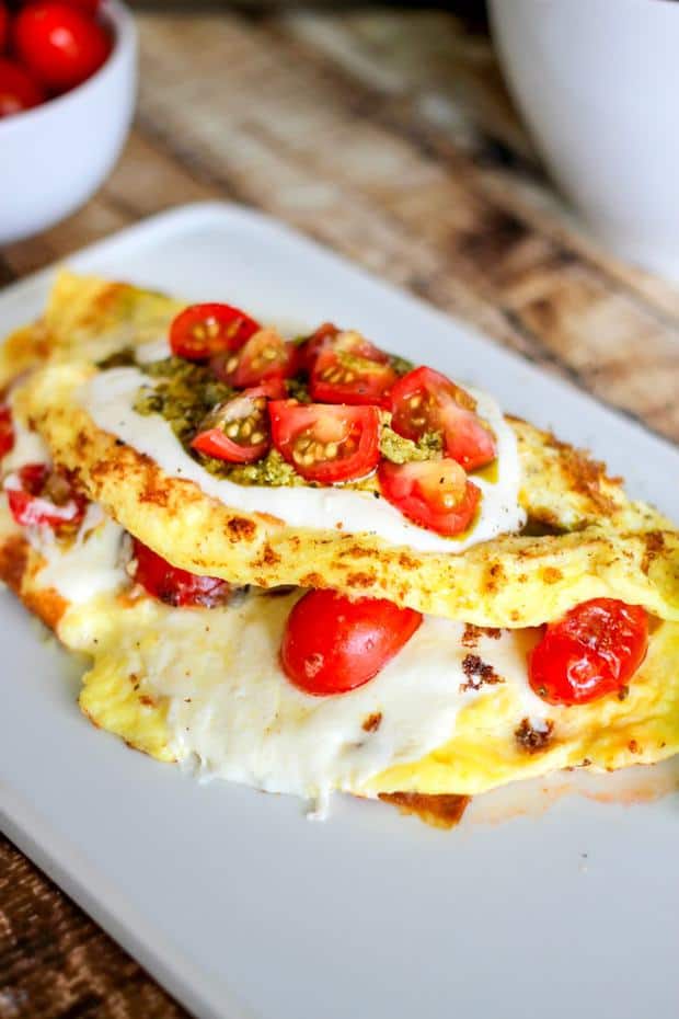 Caprese Omelette is filled with balsamic drenched fresh tomatoes, basil pesto, and mozzarella cheese. Whip this up for the perfect breakfast or brunch.