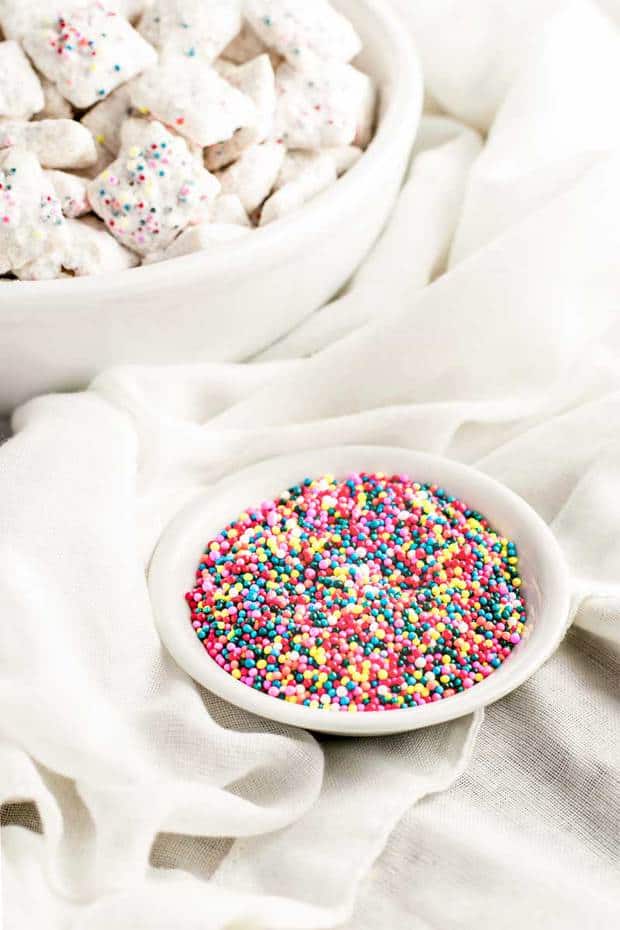 This classic sweet snack gets a festive makeover with this funfetti puppy chow! Chex cereal is coated in white candy melts, colorful sprinkles, and dusted with a sweetened white cake mix. Perfect for snacking or gifting!