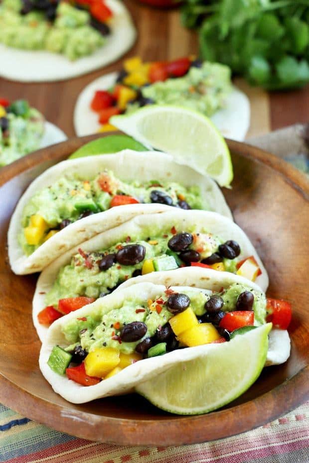 Guacamole Tacos are a savory, vegetarian taco for all those who are avocado-obsessed. Smooth creamy guacamole paired with crunchy peppers and black beans make these simple tacos flavorful and simply delicious. They will be the star of your next taco night!